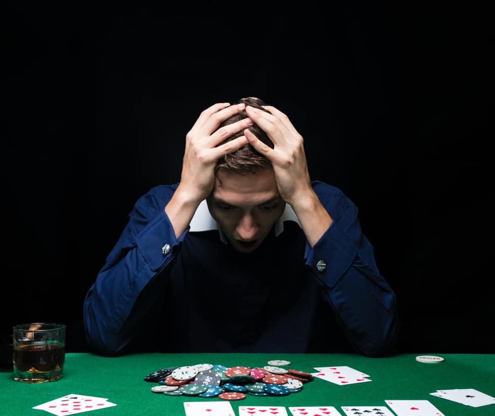 Man is playing poker. Emotional fail in game