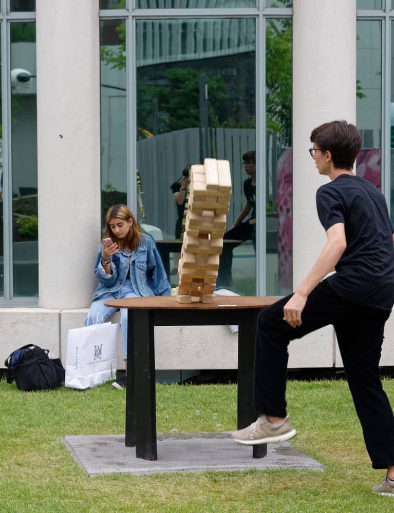 boy playing giant Jenga, and watching his tower fall