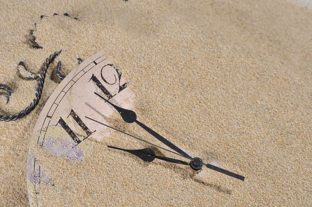 Analog Wall Clock buried under the sand poker