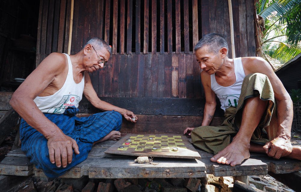 Two old men are playing a checkers game