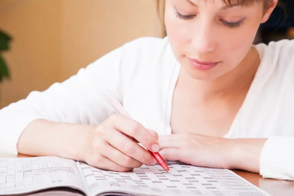 woman doing and solving a crossword