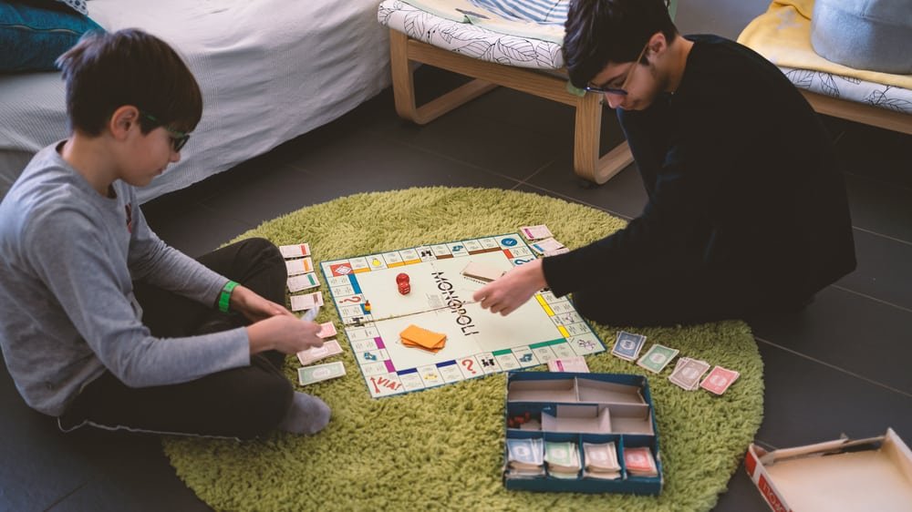 Brothers playing with Monopoly Board Game