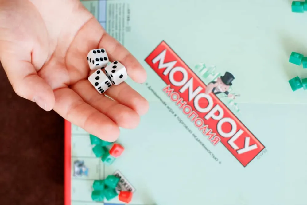 a child throws dice into the game Monopoly