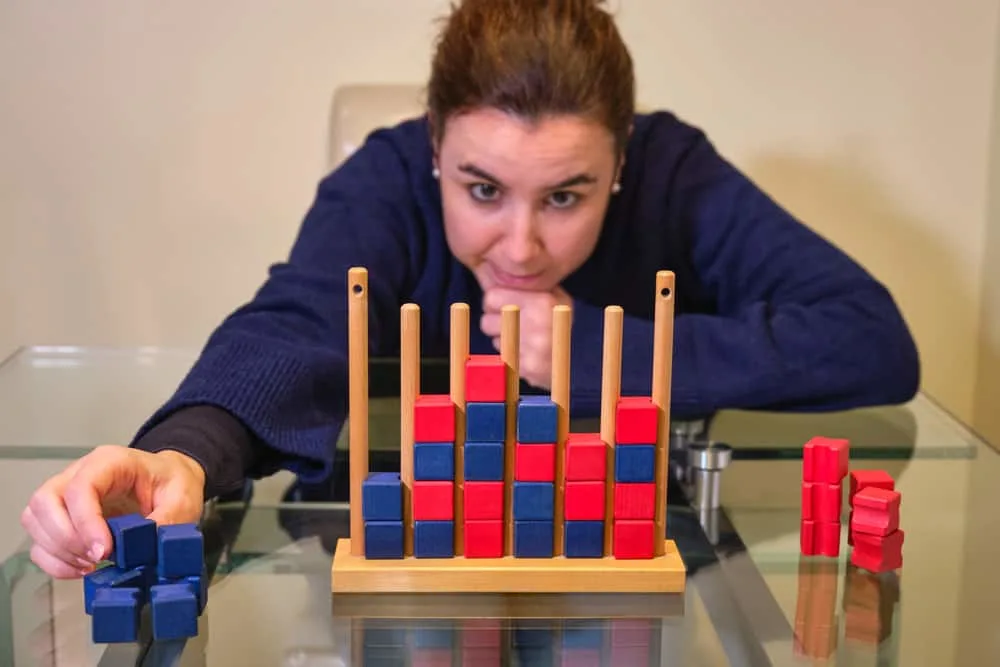 woman playing the board game connect four with red and blue pieces