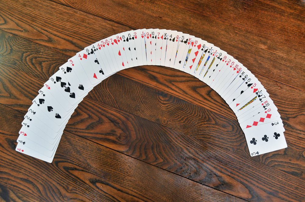 A group of playing cards on a stained oak wooden table