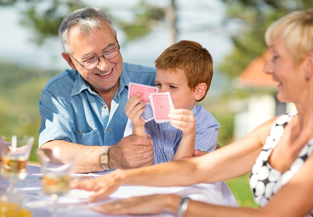 Grandfather playing cards with grandson outdoor