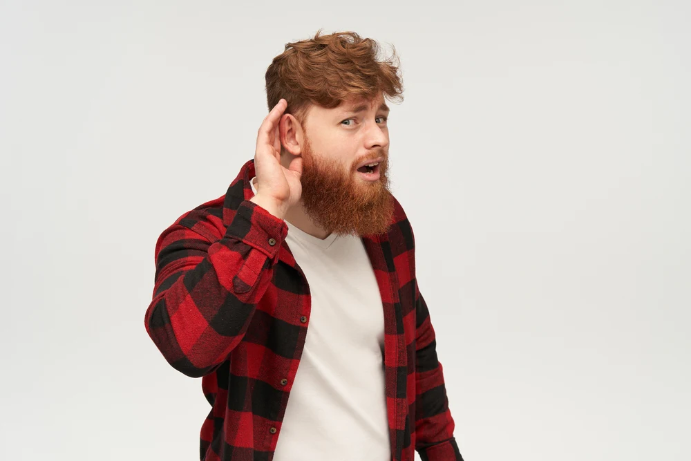 male with big red beard trying to hear something