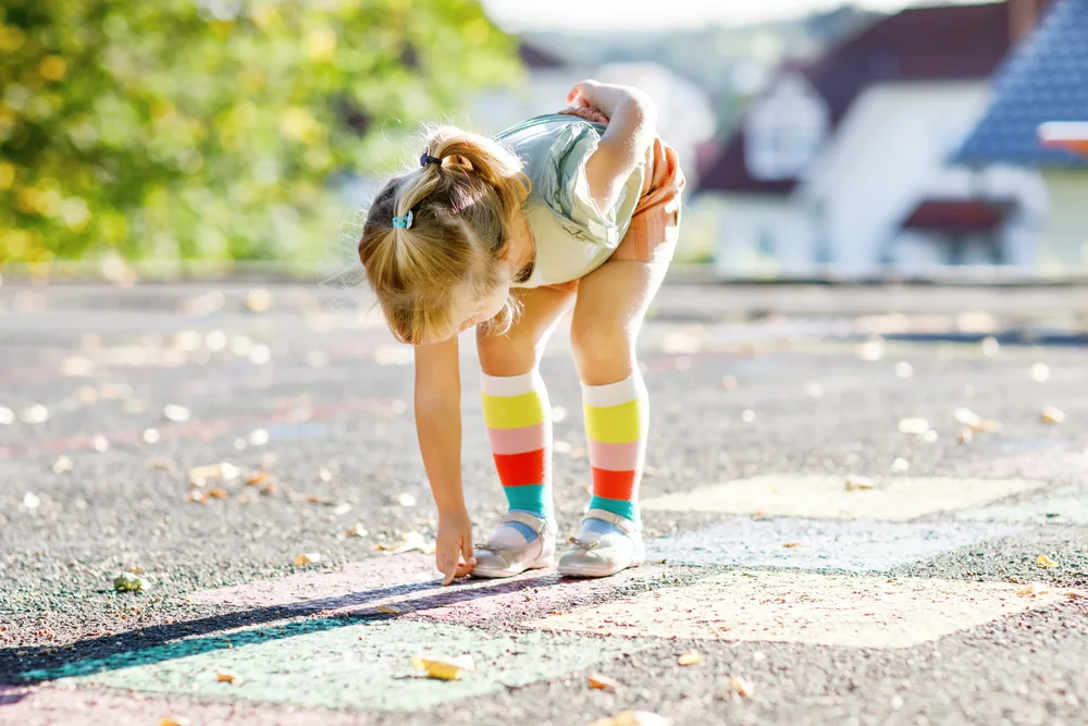 girl playing hopscotch game 