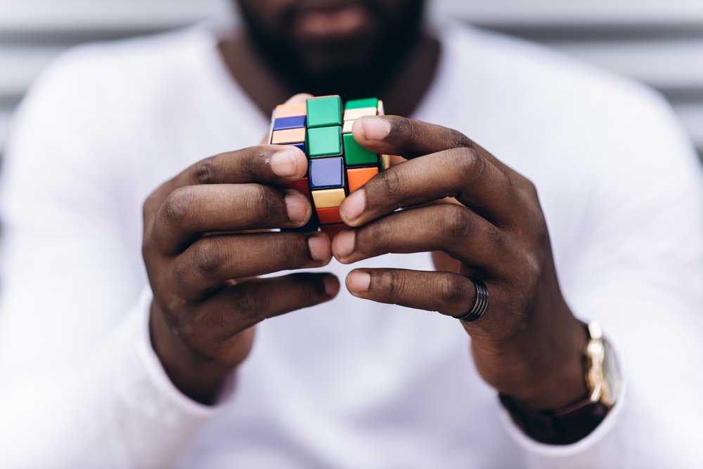 man wearing casual clothes collect Rubik's Cube