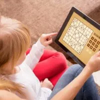 Mother and daughter playing sudoku on tablet computer
