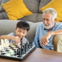 grandson playing chess with grandfather