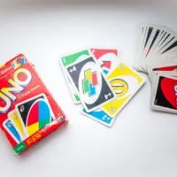 Old box of Uno card game and cards on white background 1