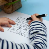 Child solves Japanese crossword sudoku