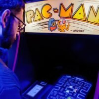Man playing with pac-man arcade console